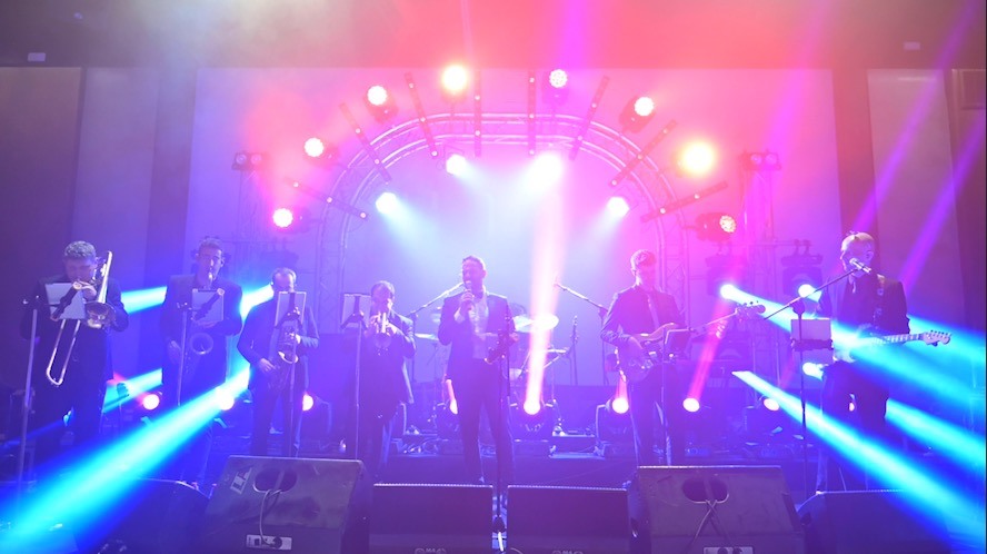 להקת Groove המלאה על במה מוארת